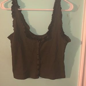 A green tank top with brownish buttons